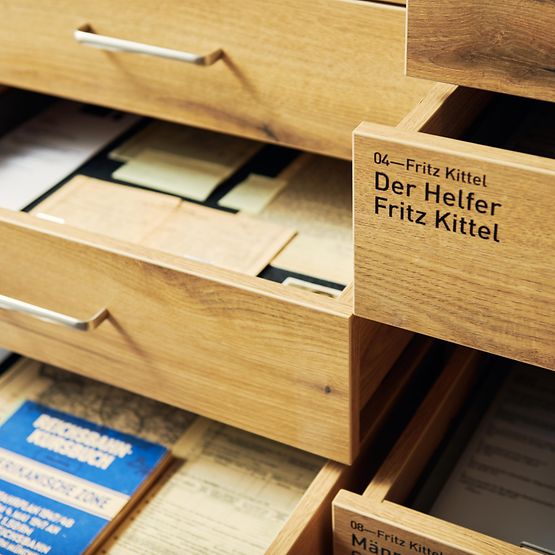 Geöffnete Schubladen eines Ausstellungsschrankes mit historischen Dokumenten
