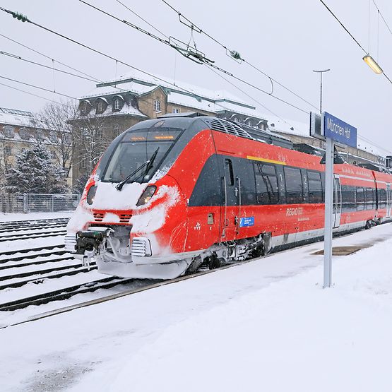 Ein DB Regio-Zug verlässt den winterlichen Münchner Hauptbahnhof.