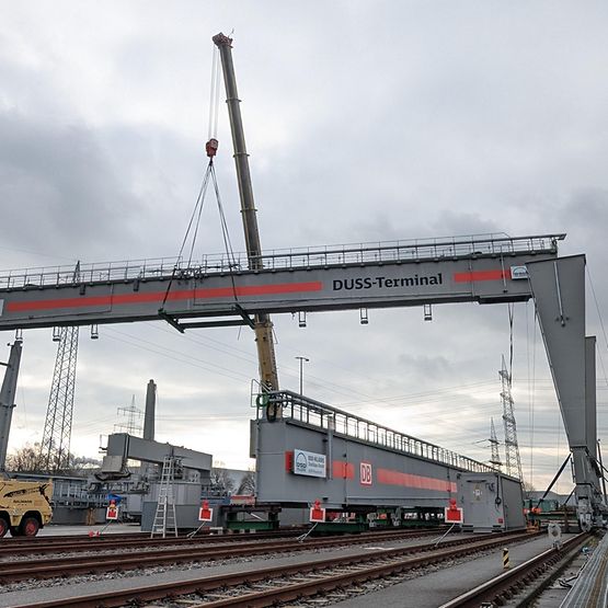Ein Kran hebt den Träger des neuen Containerkrans in die Höhe