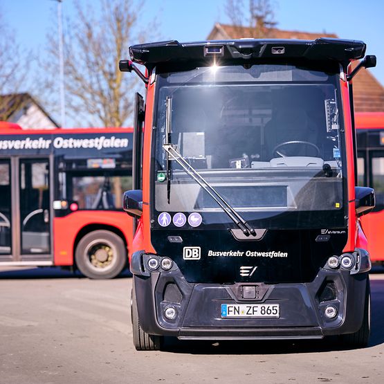 Elektrisch betriebener, autonom fahrender Kleinbus steht auf einem Betriebshof