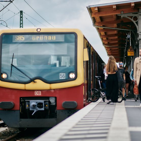 Eine S-Bahn der Linie S85 am Bahnsteig am Bahnhof Schöneweide mit aussteigenden Fahrgästen.