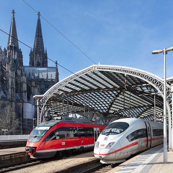 Ein ICE und eine Regionalbahn im Kölner Hauptbahnhof. Im Hintergrund der Kölner Dom