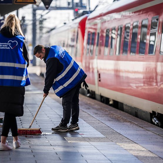 Mitarbeiter:innen reinigen Bahnsteig