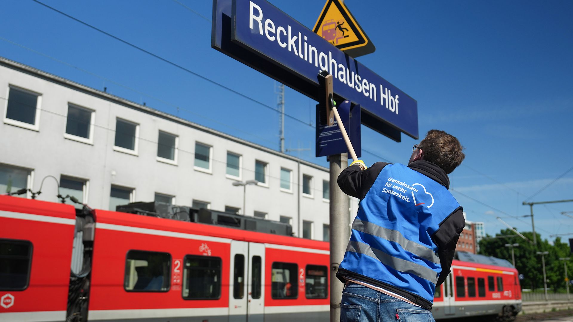 Reinigung des Bahnhfosschilds am Bahnsteig