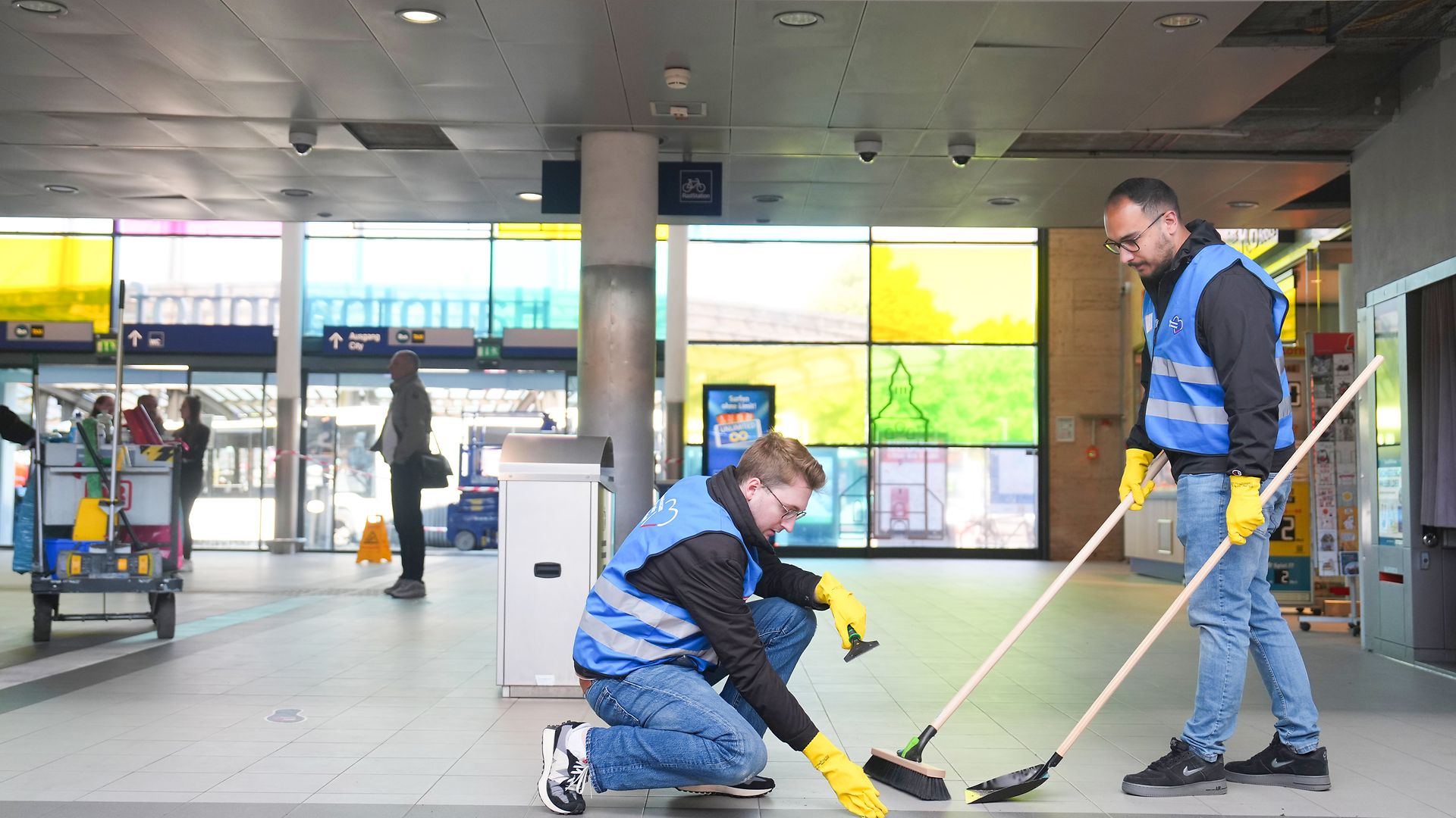 Zwei Mitarbeiter reinigen den Boden in der Bahnhofshalle der Hauptbahnhofs Recklinghausen
