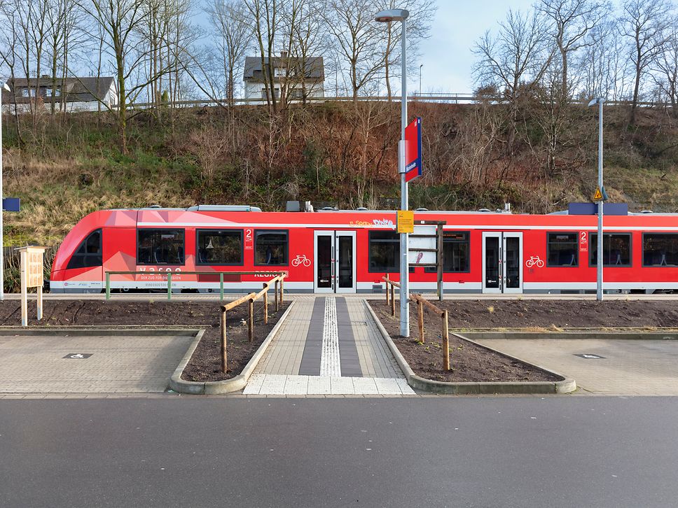 Blick auf den Bahnsteigzugang am Bahnhof Marienheide. Am Bahnsteig steht ein Zug.