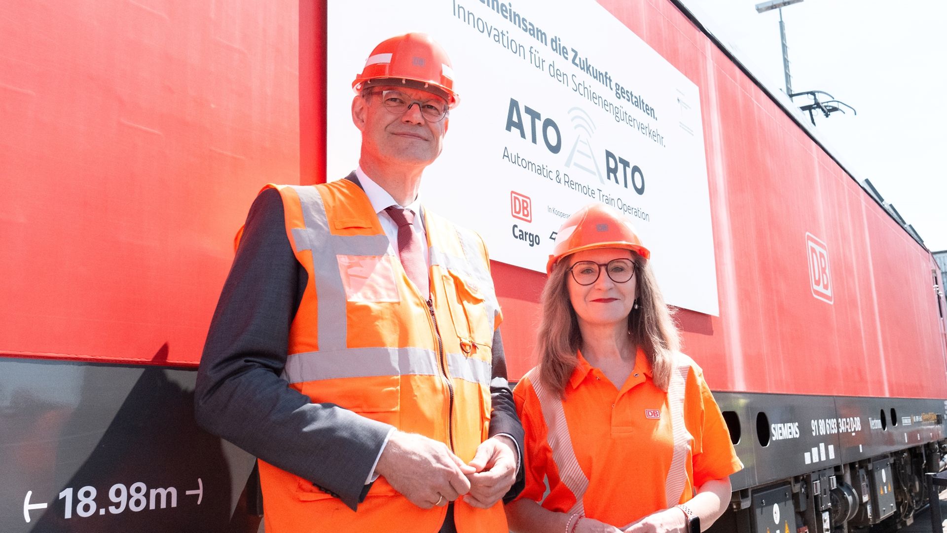 Sigrid Nikutta und Patrick Schnieder stehen vor einer roten DB Cargo Lokomotive
