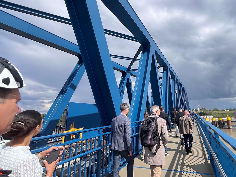 Die ersten Passanten überqueren die Ems über den neuen Rad- und Fußweg der Friesenbrücke
