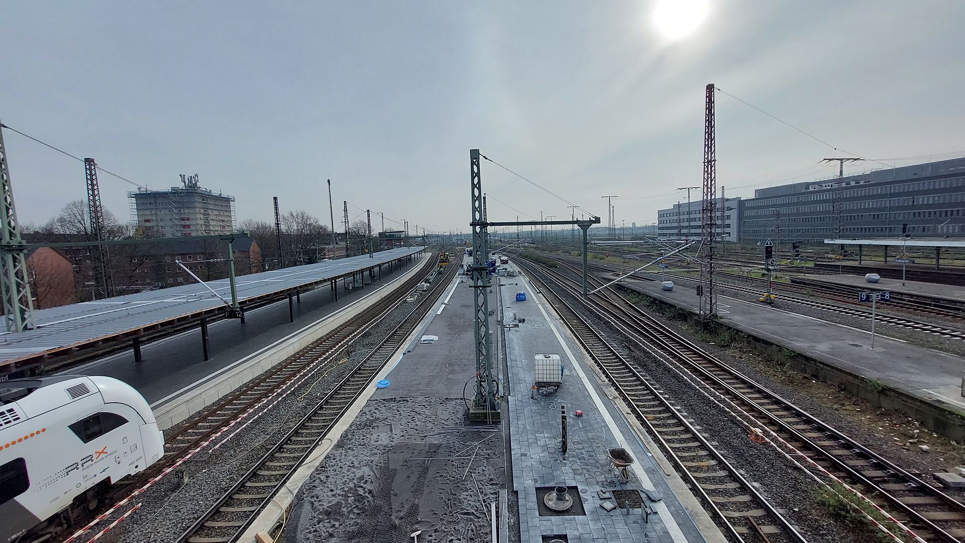 Blick von der Arbeitsbühne auf den gepflasterten Bahnsteig Richtung Düsseldorf