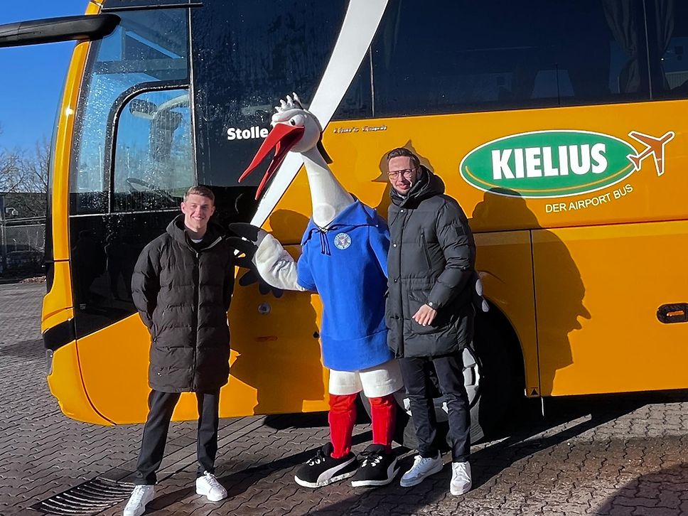 Alexander Bernhardsson von Holstein Kiel (v.l.), Vereinsmaskottchen Stolle und Daniel Marx (DB Regio Bus)