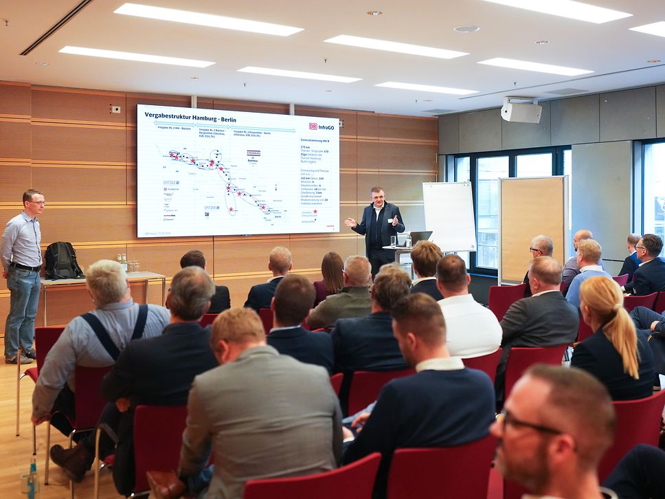 Leute hören Rednern beim Fachforum zu