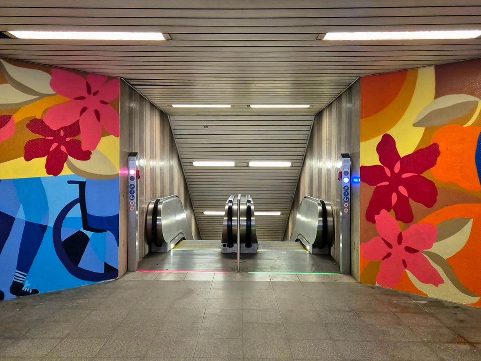 Farbenfrohe Bemalung am Lokalbahnhof an der Rolltreppe