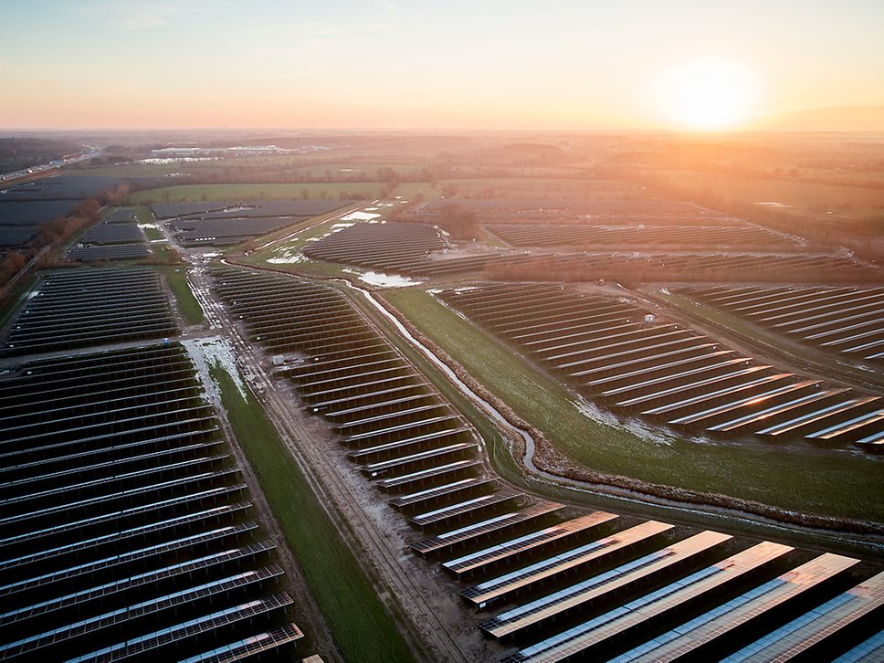Die Solaranlage in Wasbek aus der Vogelperspektive bei untergehender Sonne