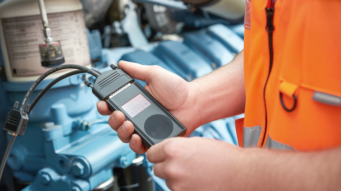 An employee uses the data flasher to tune the locomotive.