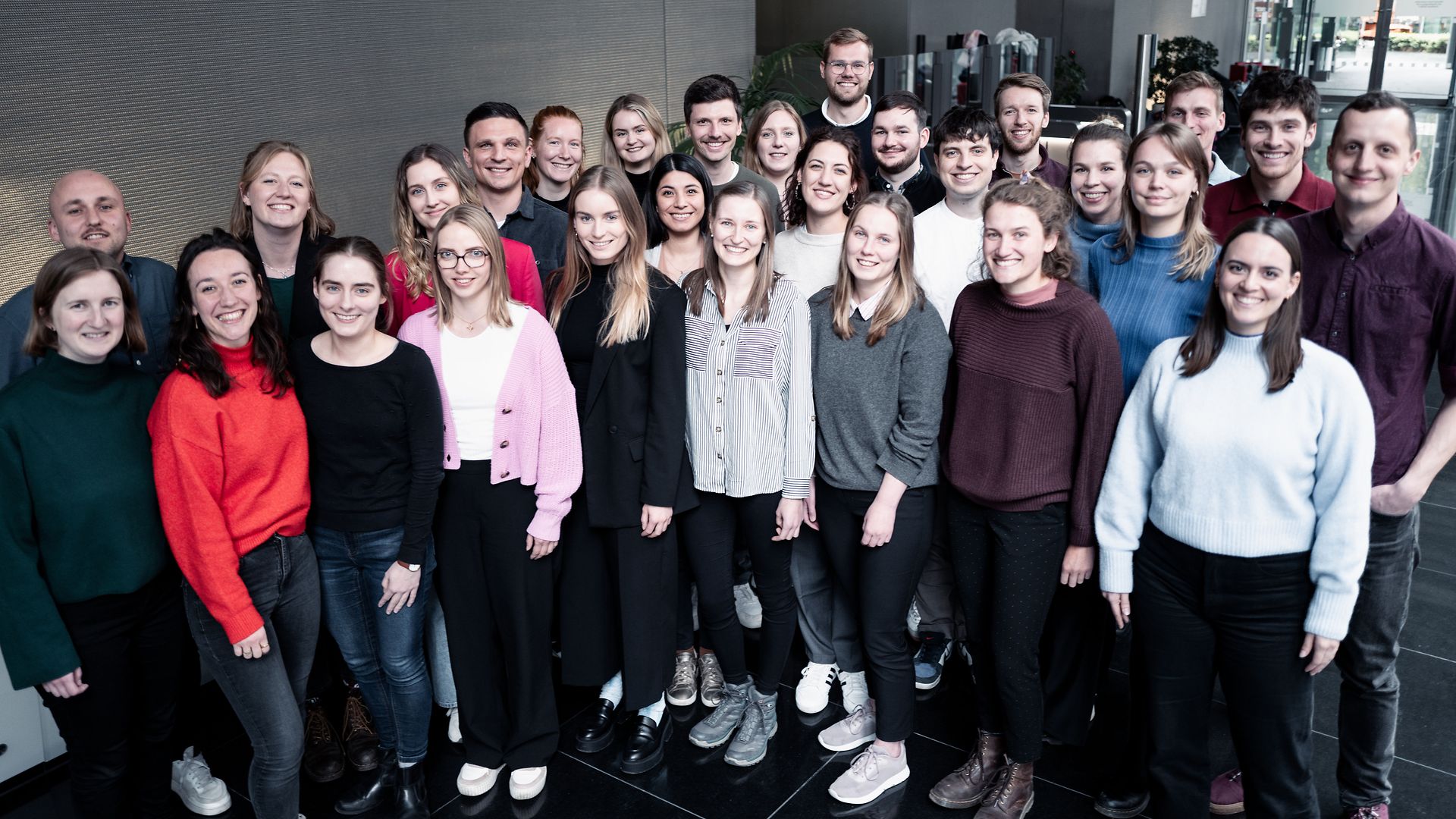 A group of young people standing together for a group picture.