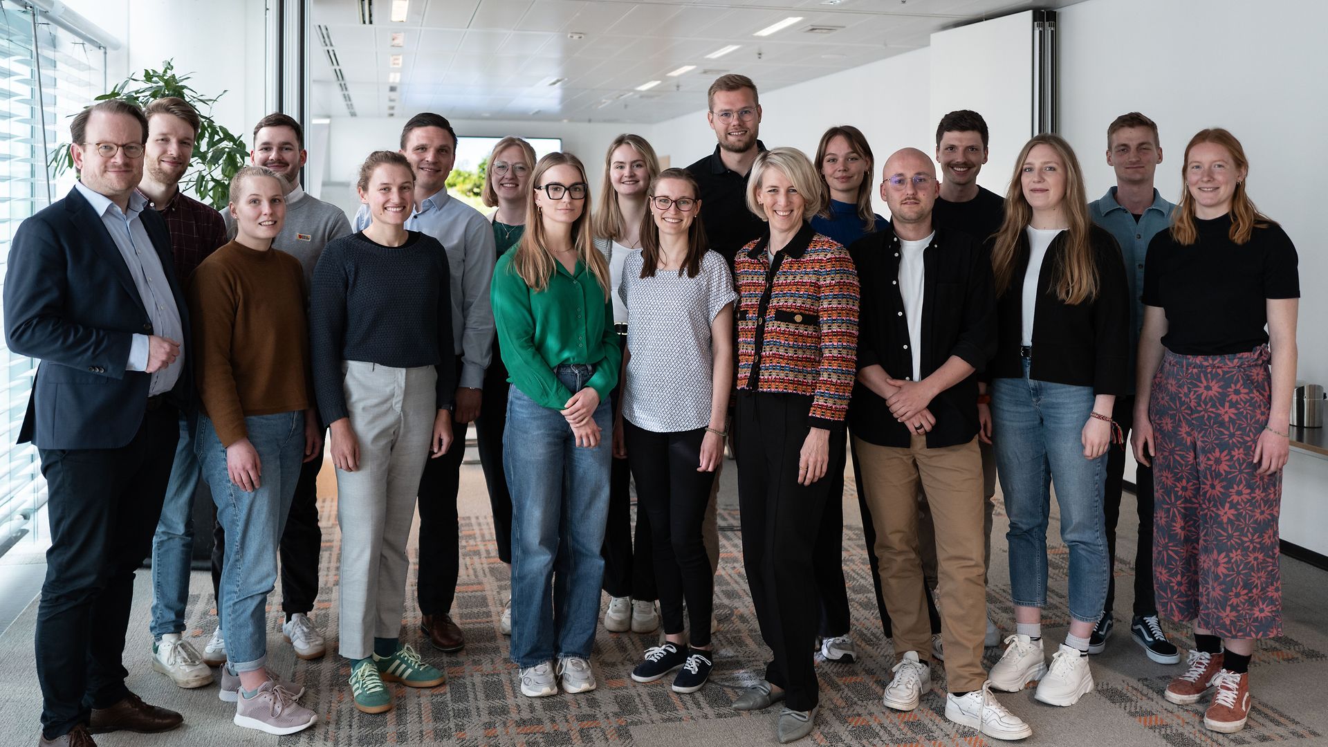 Sixteen young people standing together with sustainability executives for a group photo.