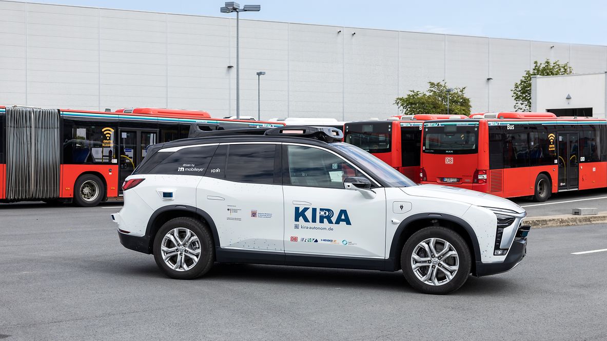 A white KIRA car in a parking lot 