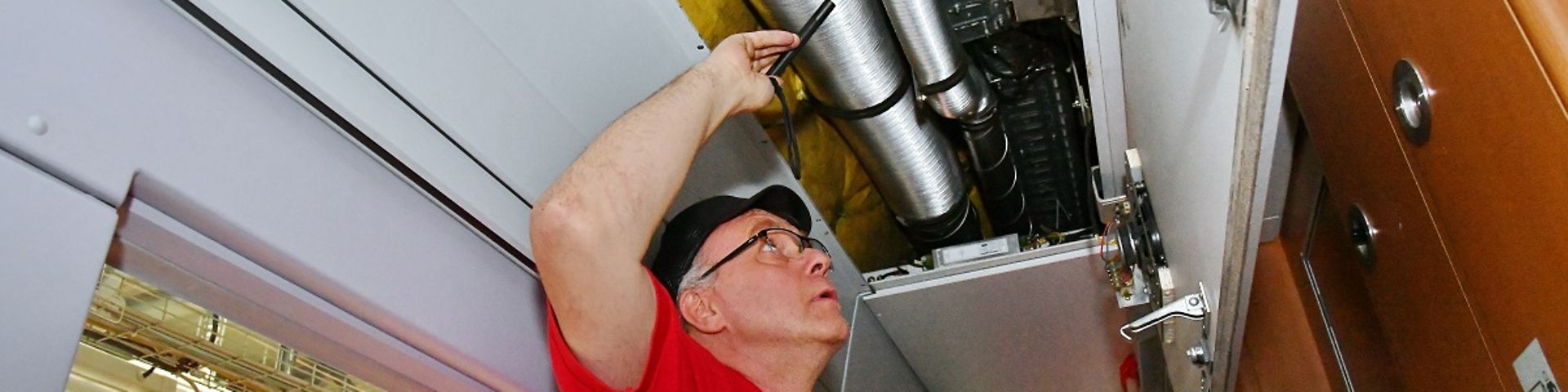 Mitarbeiter prüft, ob die Rohre der Klimaanlage eines ICE einwandfrei dicht sind