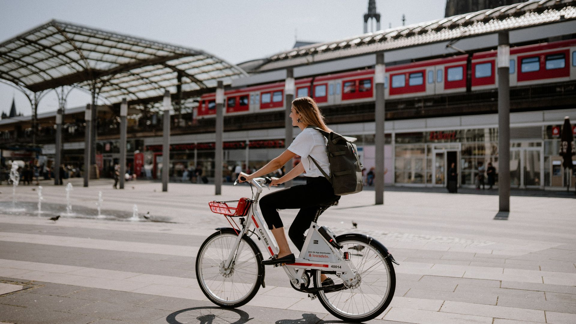 Call a Bike Radfahrerin vor Bahnhof unterwegs